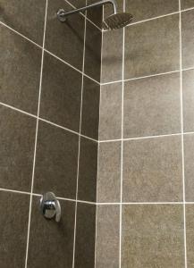 a shower in a bathroom with a tile floor at Honolulu Lifestyle Guest Lodge in Burgersfort