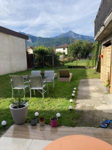 a backyard with chairs and a table and some plants at Entre lac et montagne in Cluses