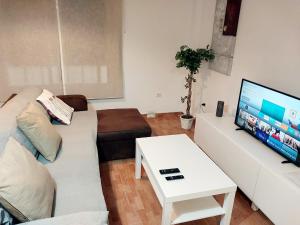 Una sala de estar con un sofá y un televisor. en Apartamento Urb La Tortuga I, en Tarifa