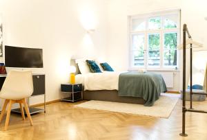 a bedroom with a bed and a desk and a television at The Gallery in Munich