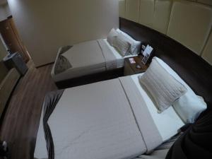 a hotel room with two beds and a night stand at Elite Grand City in Cairo