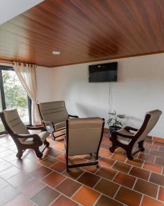une salle d'attente avec des chaises et une télévision à écran plat dans l'établissement Prana, à Isnos
