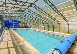 a large swimming pool with a glass wall at The Carriage House Upcott House in Barnstaple