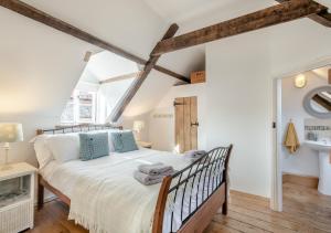a bedroom with a large bed with blue pillows at 1 Cutty Sark Cottages in West Runton