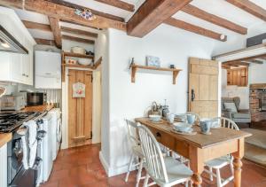 a kitchen with a wooden table and chairs at 1 Cutty Sark Cottages in West Runton