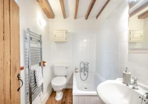 biała łazienka z toaletą i umywalką w obiekcie 1 Cutty Sark Cottages w mieście West Runton