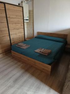 Appartamento lake-side في كالسرانيكا ال لاغو: غرفة نوم بسرير وملاءات زرقاء وارضيات خشبية