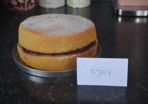 a cake sitting on top of a table with a sign at Larksfield Snug in Debach