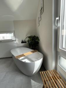 a large white bath tub in a room with a bench at ZugZuflucht-neues, modernes Ferienhaus in Freiberg