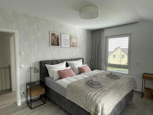 um quarto com uma cama grande e almofadas cor-de-rosa em ZugZuflucht-neues, modernes Ferienhaus em Freiberg