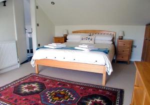 a bedroom with a large bed and a rug at Harbour Lights in Torquay