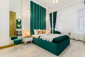 a green bedroom with a bed and a table and chairs at Golden Greens Studio - Luxury Design & Self Check-in in Braşov
