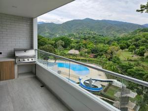 a balcony with a view of a pool and mountains at Espectacular apartamento en santa fe de antioquia cerca al parque de lujo nuevo in Santa Fe de Antioquia