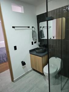 a bathroom with a toilet and a sink and a mirror at Espectacular apartamento en santa fe de antioquia cerca al parque de lujo nuevo in Santa Fe de Antioquia