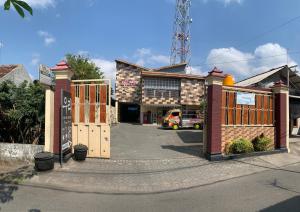 a building with wooden gates and a parking lot at Butterfly Kost Tulungagung in Ngantru