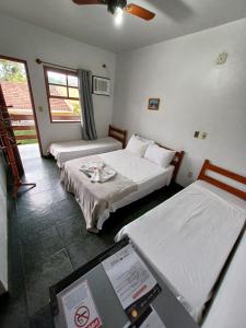 a room with two beds and a scale in it at Pousada da Jaqueira - EPP in Rio das Ostras