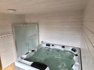 a bath tub in a bathroom with a shower at Domek Wester House Fuleda z Sauną Jacuzzi i Kominkiem in Giżycko