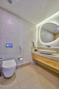 a bathroom with a white toilet and a sink at Lilium Boutique Hotel in Antalya