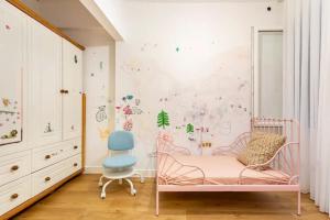 伊斯坦堡的住宿－4 Bedroom Spacious Apartment in Nisantasi，一个带粉红色婴儿床和蓝椅的幼儿园