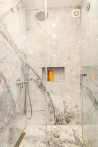 uma casa de banho com um chuveiro e uma porta de vidro em 4 Bedroom Spacious Apartment in Nisantasi em Istambul