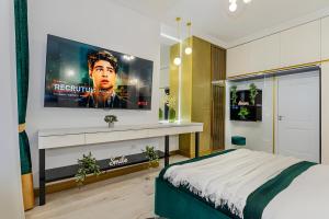 ein Schlafzimmer mit einem großen TV an der Wand in der Unterkunft Golden Greens Studio - Mountain Scenery in Braşov