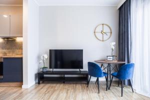 Nowe Ptasie, Osiedle Ptasie, apartment 29, NEW - LUX - PARKING في كاتوفيسي: غرفة معيشة مع تلفزيون وطاولة وكراسي