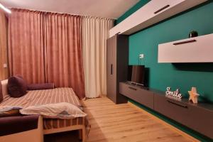 a bedroom with a bed and a flat screen tv at Urban Retreat Barlad in Bîrlad