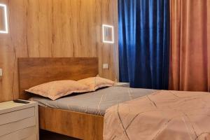 a bedroom with a bed with a blue curtain at Urban Retreat Barlad in Bîrlad