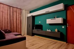 a living room with a couch and a green wall at Urban Retreat Barlad in Bîrlad