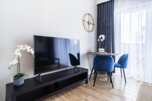 un soggiorno con TV, tavolo e sedie di Nowe Ptasie, Osiedle Ptasie, apartment 29, NEW - LUX - PARKING a Katowice