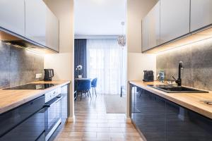 a kitchen with white cabinets and wooden counter tops at Nowe Ptasie, Osiedle Ptasie, apartment 29, NEW - LUX - PARKING in Katowice