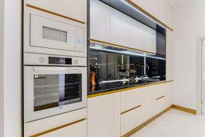 a kitchen with white cabinets and a sink at Golden Greens Studio - Luxury Design & Self Check-in in Braşov