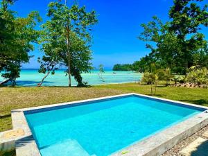 a swimming pool with the beach in the background at Lope Lope Beach Bungalows in Luganville