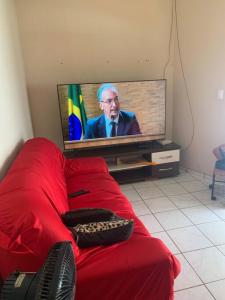 a living room with a red couch and a tv at Residência lençóis in Barreirinhas