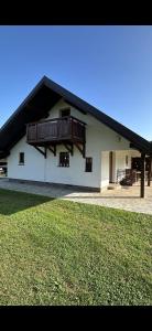 ein weißes Haus mit einem Balkon und einem Hof in der Unterkunft Sweet Country House in Markovci