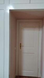 a white door with a gold handle in a room at Stadthaus Room1 neben REM -MUSEUM mit Hochbett für 2 Persons oder kleine Familie in Mannheim