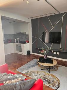 uma sala de estar com um sofá vermelho e uma mesa em @Derricks Luxury Apartments 2 em Joanesburgo