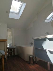 La salle de bains est pourvue d'une baignoire et d'une fenêtre. dans l'établissement Charmante maison dans joli village, à Vouhé