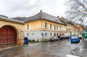 a city street with cars parked in front of buildings at Golden Greens Studio - Luxury Design & Self Check-in in Braşov