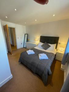a bedroom with a large bed with two towels on it at Blue Sky Apartments@ Abbots Yard, Guildford in Guildford
