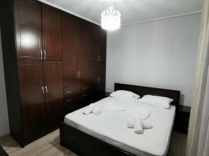 a bedroom with a bed with wooden cabinets and a chandelier at Relaxing Getaway in Gjirokastër