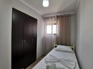 a bedroom with a bed with a black cabinet and a window at Relaxing Getaway in Gjirokastër