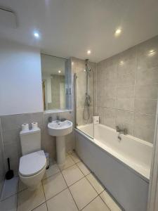 e bagno con servizi igienici, vasca e lavandino. di Blue Sky Apartments@ Abbots Yard, Guildford a Guildford