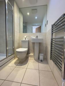 a bathroom with a toilet and a sink and a shower at Blue Sky Apartments@ Abbots Yard, Guildford in Guildford