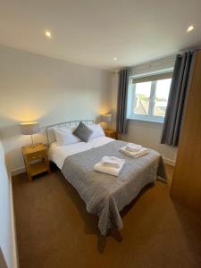 um quarto com uma cama com duas toalhas em Blue Sky Apartments@ Abbots Yard, Guildford em Guildford