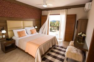 a bedroom with a bed and a large window at Pousada Lusitânia in Pedra Azul