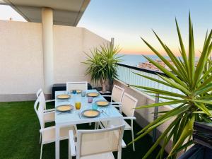 a table on a balcony with a view of the ocean at PATACONA PREMIUM PENTHOUSE Sea views & Barbecue in Valencia