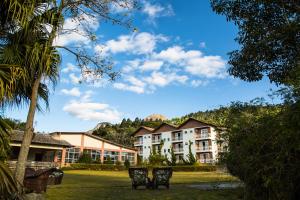 a view of a building with two chairs in a yard at Pousada Lusitânia in Pedra Azul