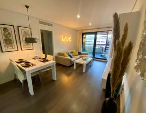 uma sala de estar com uma mesa branca e um sofá em PATACONA PREMIUM PENTHOUSE Sea views & Barbecue em Valência