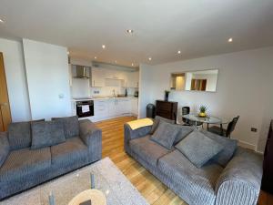 a living room with two couches and a kitchen at Blue Sky Apartments@ Abbots Yard, Guildford in Guildford